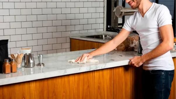 hombre limpiando encimera de cocina laminado HPL